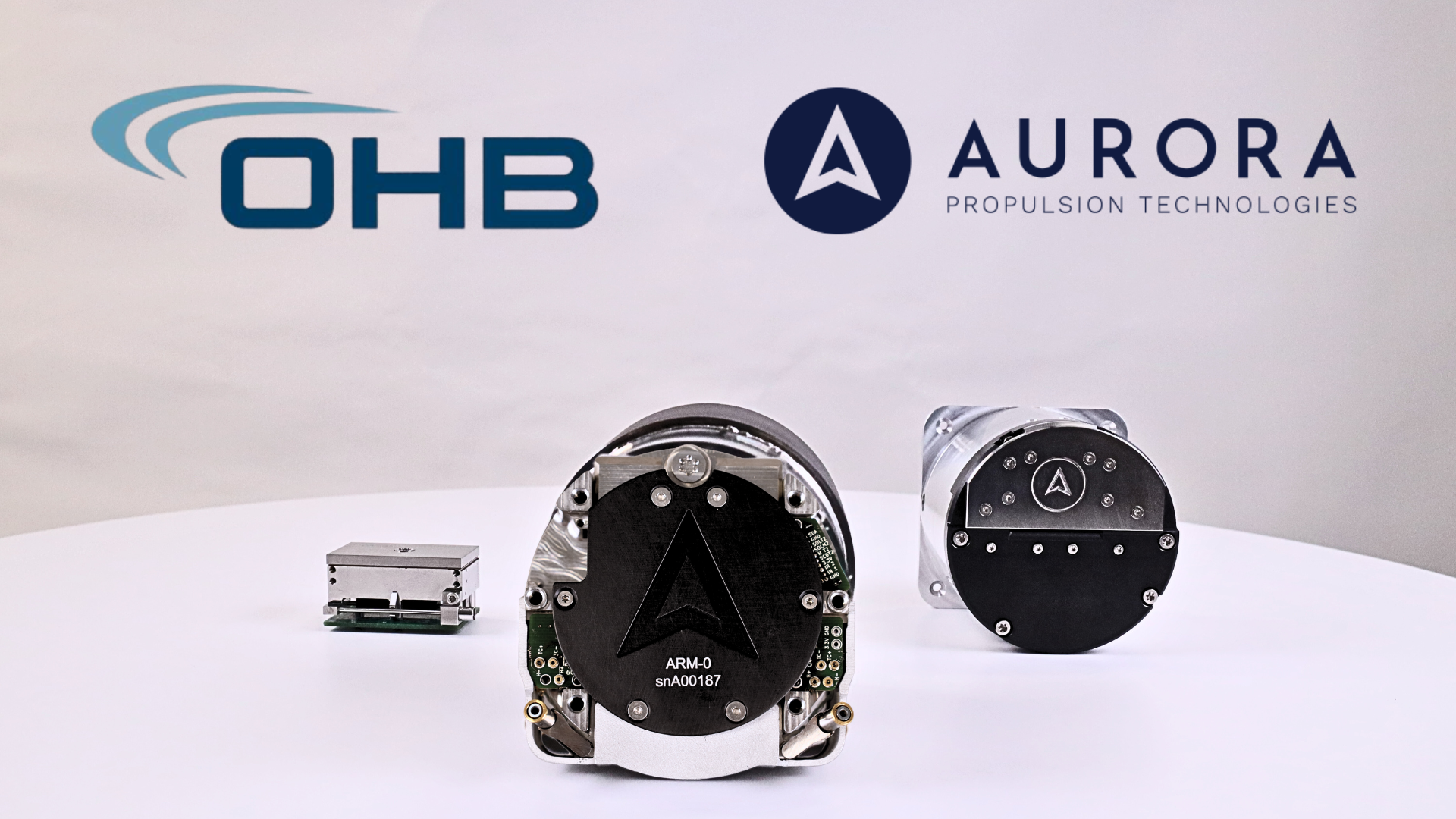 OHB System AG and Aurora Propulsion Technologies logos above ARM-C, ARM-O, and TunaCan Plasma Brake satellite hardware.