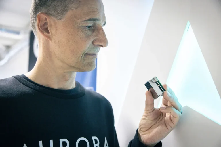 Aurora CEO Pekka Blomberg holding a water-powered nanosatellite thruster in the Otaniemi lab